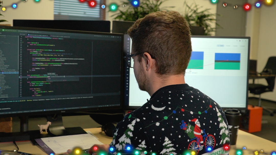 BIM4Production medewerker in een kersttrui die aan het programmeren is